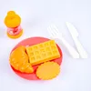 A toy breakfast set with a juice bottle, croissant, waffle, and cookie on a red plate, with a fork and knife. Produktbild-Vorschau