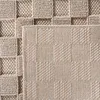 A close-up view of a textured beige rug with a woven checkerboard pattern. Podgląd zdjęcia produktu