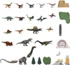 A collection of dinosaur toys and accessories arranged on a white background. Produktbild-Vorschau