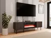 A modern living room setup featuring a TV stand with a fireplace, a large television, and a potted plant. Náhled obrázku produktu