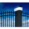 A solar-powered light fixture on a fence post at night. Voir les images du produit