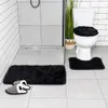 A bathroom scene with a toilet, shower, and bath mats. Produktbild-Vorschau