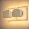 Two LED night lights with motion sensors plugged into wall outlets, emitting a warm glow. Produktbild-Vorschau