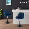 Two blue velvet bar stools are shown in a modern interior setting with a bar counter and a painting on the wall. Náhľad obrázku produktu