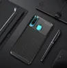 A smartphone case with a carbon fiber texture is displayed on a dark surface, alongside a notebook and a pen. Podgląd zdjęcia produktu