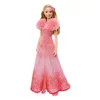 A doll wearing a pink dress. Voir les images du produit