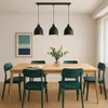 A dining room setting with a wooden table and chairs, illuminated by a pendant light. Produktbild-Vorschau