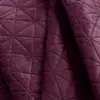 A close-up of a quilted blanket with a diamond pattern. Produktbild-Vorschau