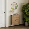 A shoe cabinet with two flip drawers is placed next to a door and a large potted plant. A round mirror hangs on the wall above the cabinet. Podgląd zdjęcia produktu