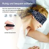 A woman sleeping wearing a sleep mask with integrated headphones. Produktbild-Vorschau