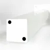 A close-up, low-angle shot of a white table leg with two black circular feet on its base. Produktbild-Vorschau