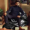 A man is sitting on a bean bag chair in a modern living room setting. Podgląd zdjęcia produktu