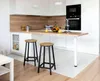 A modern kitchen with white cabinets, a wooden countertop, and two bar stools. Náhled obrázku produktu