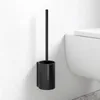 A black toilet brush holder mounted on a white wall next to a toilet. Anteprima dell’immagine prodotto