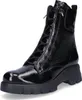 A black patent leather boot with laces and a thick sole, shown from the front. Produktbild-Vorschau