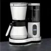A white and silver coffee maker with a thermal carafe and a digital display is shown against a black background. Voir les images du produit