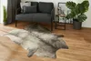 Graues Rinderfell-Imitat vor Sofa im Wohnzimmer dekorativ platziert
 Produktbild-Vorschau