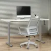A white height-adjustable desk with a computer and chair in an office setting. Podgląd zdjęcia produktu