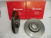 Two Brembo brake discs are displayed in front of their red packaging boxes. Produktbild-Vorschau