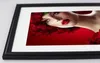 A framed picture of a woman's face adorned with red roses, displayed on a white surface. Produktbild-Vorschau