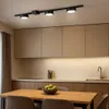 A modern kitchen with a dining table in the foreground and a track light fixture above. Produktbild-Vorschau