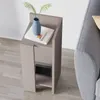 A modern side table next to a gray sofa, with a vase and book on top. Podgląd zdjęcia produktu