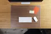 A desk with a transparent desk mat, keyboard, and mouse. Produktbild-Vorschau