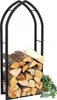 A black metal firewood rack filled with logs, with a small potted plant to the right. Podgląd zdjęcia produktu
