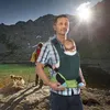 A father carries his baby in a carrier while hiking in the mountains with his child and dog. Produktbild-Vorschau