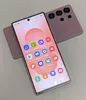 A pink smartphone is shown from a diagonal angle, with its screen facing the viewer. Another identical phone is placed behind it, showing its rear camera module. Produktbild-Vorschau