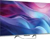 A Haier television with a colorful abstract image displayed on its screen, shown from a side angle on a stand. Voir les images du produit