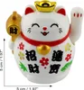 A white Maneki-neko (lucky cat) figurine with red and gold accents, holding a gold ingot and a gold mallet. It has Chinese characters and floral designs on its body. There are also size indicators on the left and bottom of the image. Produktbild-Vorschau