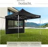 A black pop-up gazebo is set up on a green lawn in front of a modern house and a swimming pool, with mountains in the background. Produktbild-Vorschau
