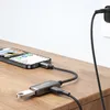 A smartphone is connected to an OTG adapter which is plugged into a USB flash drive and a charging cable. The setup is on a wooden surface. Náhľad obrázku produktu
