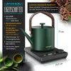 A green electric kettle with a wooden handle sits on its charging base, next to two small green cups. Text overlays describe the product's features and benefits. Podgląd zdjęcia produktu
