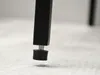 Close-up of the adjustable foot of a black table leg on a textured surface. Náhled obrázku produktu