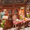 A miniature coffee bar scene with tables, chairs, and decorative elements. Podgląd zdjęcia produktu