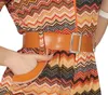 Close-up of a person wearing a patterned dress and a belt. Produktbild-Vorschau