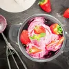 A close-up of a metal bowl filled with strawberry ice cream, garnished with fresh strawberries and mint leaves. An ice cream scoop is visible to the left. Produktbild-Vorschau