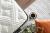 A close-up view of a mattress with a cup of coffee and a pillow nearby, suggesting a comfortable bedroom setting. Produktbild-Vorschau
