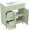 A light green bathroom vanity with a white sink and open drawers and doors, shown against a white background. Anteprima dell’immagine prodotto