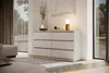 A modern bedroom with a white dresser, a lamp, and a vase with branches. Produktbild-Vorschau