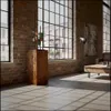 A modern loft-style living room with large windows, brick walls, and concrete floors, featuring a wooden pedestal with a decorative sculpture. Voir les images du produit