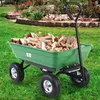 A green garden cart filled with firewood sits on a grassy lawn in front of a landscaped garden. Náhled obrázku produktu