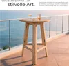 A wooden bar table with drinks on a balcony overlooking the ocean. Produktbild-Vorschau