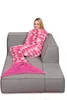 A woman is sitting on a couch wearing a mermaid tail blanket. Anteprima dell’immagine prodotto