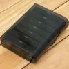 A black pill organizer with days of the week labeled on it, placed on a wooden surface. Podgląd zdjęcia produktu