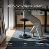 A person is sitting on an adjustable stool at a desk. Produktbild-Vorschau