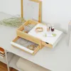 A jewelry box with jewelry and cosmetics on a white desk. Voir les images du produit