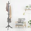 A gray wooden coat rack with items hanging on it, placed in a room with a chair and a lamp. Produktbild-Vorschau